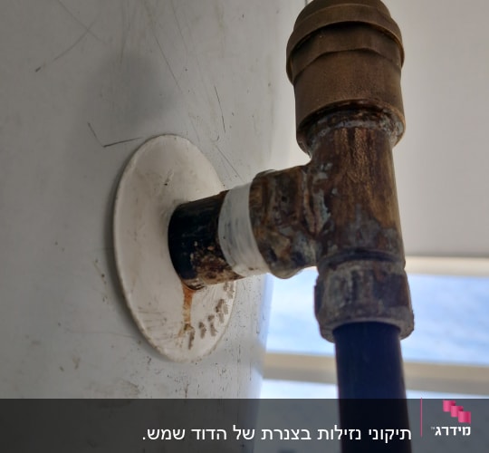צינור מחובר לברז חלוד על דוד מים